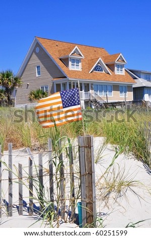 Pretty beach scene with rental home, dune and American flag. Perfect for cover art.