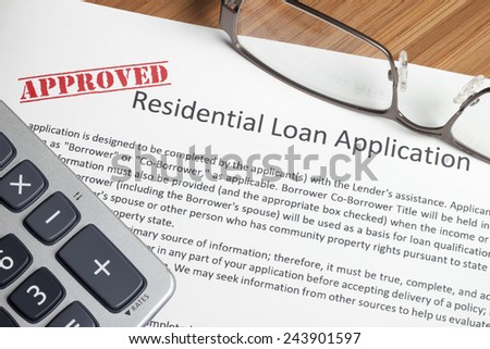 A house key sitting on mortgage application.