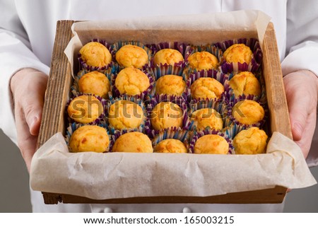 Corn muffins in a box in the hands of the chef