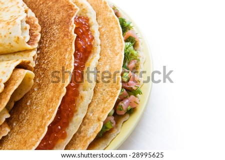 Russian pancakes with a stuffing from red caviar and a salmon (top left view)