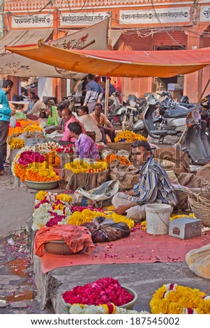 JAIPUR, INDIA - MARCH 25, 2014:  Traders selling flower garlands for use as offerings at  a nearby Hindu shrine in the Tripolia Bazaar district of the old city