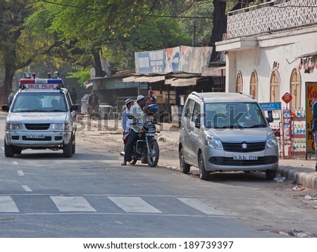 DELHI, INDIA - MARCH 17, 2014: Street scene in the early evening with a police patrol on a street in the old city