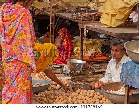 JAIPUR, INDIA - MARCH 26, 2014: Traders and customers in the fruit and vegetable market in the old Johari Bazaar district of the city