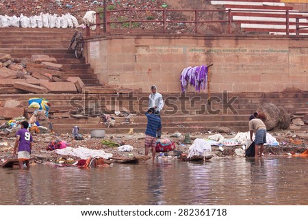 VARANASI, INDIA - MARCH 3, 2015: Professional washermen, known as dhobis, at work in the early morning on the banks of the river Ganges
