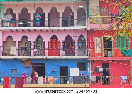 DELHI, INDIA - MARCH 14, 2015: Residents on the balconies of some of the colorful social housing in the Haus Khas village district of the city