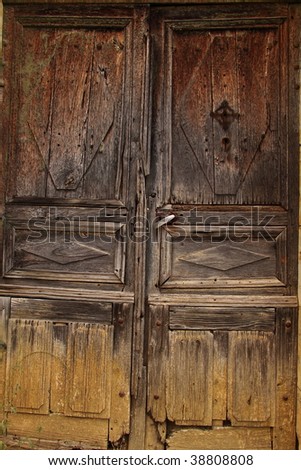 Dilapidated door with new handle at the entrance to an old French farmhouse