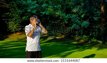 The golfer accurately measures the distance to the flag in a golf course with the laser rangefinder. In the background the forest. Сток-фото © 