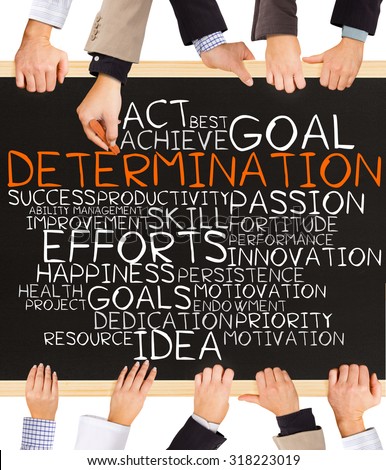 Photo of business hands holding blackboard and writing DETERMINATION word cloud