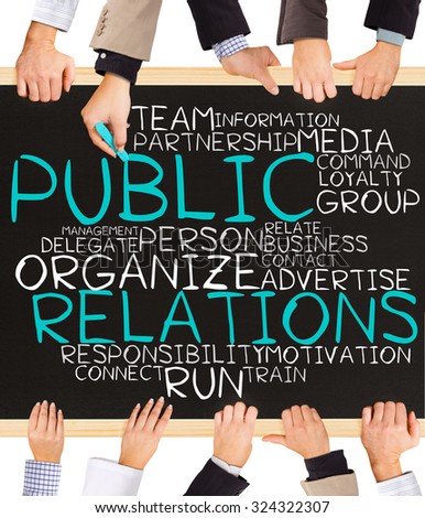 Photo of business hands holding blackboard and writing PUBLIC RELATIONS word cloud
