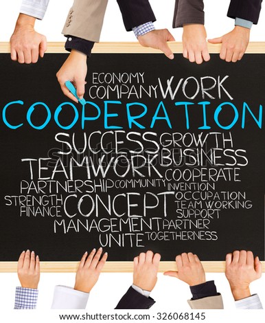 Photo of business hands holding blackboard and writing COOPERATION concept