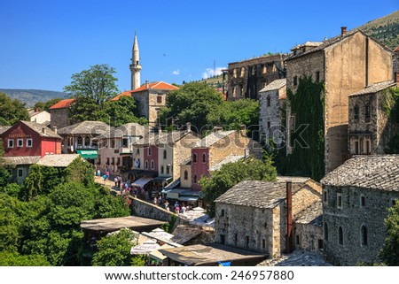 MOSTAR, BOSNIA AND HERZEGOVINA-JULY 20 : People walking through the Old Town with many shops and cafes on July 20, 2014 in Mostar, Bosnia and Herzegovina. Mostar is situated on the Neretva River.