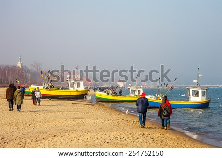 SOPOT, POLAND - FEBRUARY 14: Baltic coast beach scene of many people walk, relaxing and enjoying the shore in Valentines Day, on February 14, 2015 in Sopot, Poland.