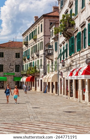 KOTOR, MONTENEGRO - JULY 18:People walk on Square of Arms in Kotor Old Town in the background many shops, on July 18, 2014 in Kotor, Montenegro. Kotor it is a very popular travel destination of Europe