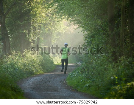 Older woman running into distance on countryside track