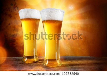 Beer in a glass with gold background