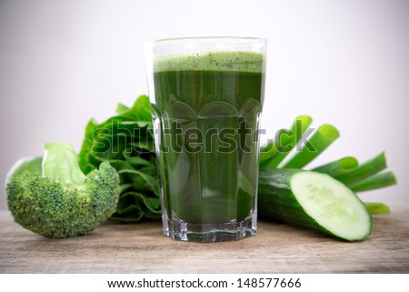 Healthy green vegetable juice on wooden table