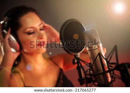 Young singer singing on the studio microphone