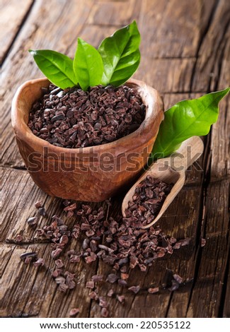 Cocoa pod with bowl on a dark wooden table, close-up.