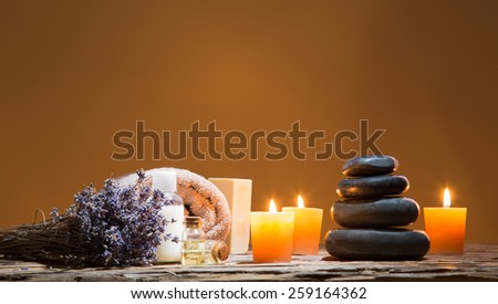 Spa still-life with stacked of stone and burning candles, close-up.