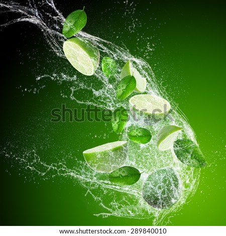 Limes with water splash isolated on dark background