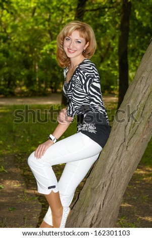 happy beautiful girl black and white clothes sitting tree