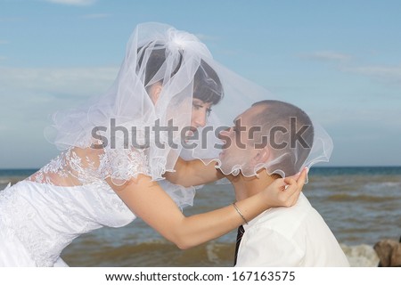 bride and groom  gentle kiss  against the background of the sea