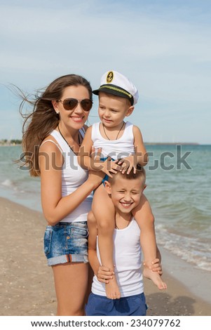 Happy family. Young happy beautiful  mother and her two sons having fun on the beach. Positive human emotions, feelings, emotions.