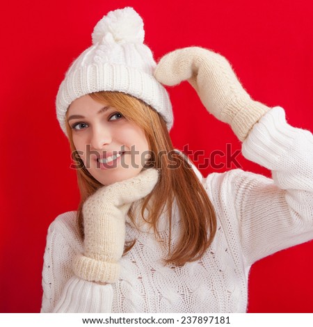 Beauty Girl wearing fashion white knitted hats and mittens. Winter cold  holiday. Woman in red background portrait.