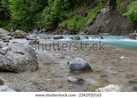 Foto Bild Schneller Fluss, der durch ein Bergtal fließt