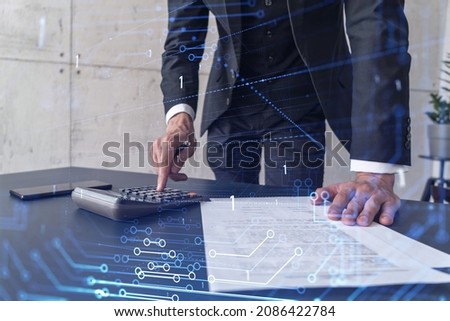 A research and development specialist computing the data to create a new approach to develop high tech business. Technological icons over the desk with calculator. 商業照片 © 