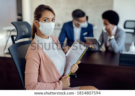 Portrait of a woman wearing a face mask while having job interview in the office during coronavirus epidemic.  商業照片 © 