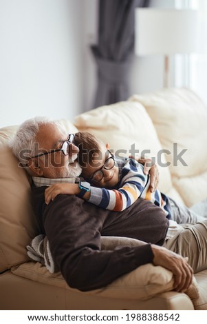 Happy little boy embracing his grandfather while spending time together at home.  Foto stock © 