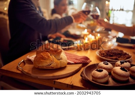 Close-up of traditional Jewish food on dining table with family toasting in the background. Foto stock © 