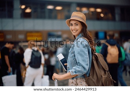 Foto Bild Frau am Flughafen, die auf die Fluginformationstafel schaut.