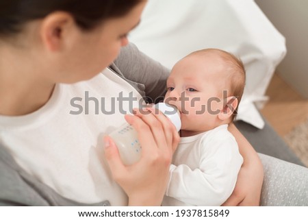 Similar – Image, Stock Photo Mother bottle feeding newborn