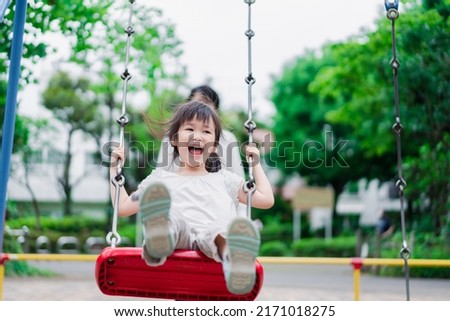 Similar – Image, Stock Photo Father and mother swinging their baby sitting on the green grass in the park. Infant is laughing happy.