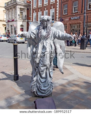WORCESTER,UK-APRIL 29 2014:Performing street artist posing as an angel statue to earn money on APRIL 29 2014 in Worcester-UK