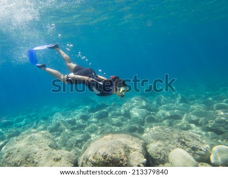 LOUTRA,GREECE-AUGUST 24 2014 :A female snorkeler dives beneath the surface to explore underwater.Snorkeling is an easy sport for all ages to take part in