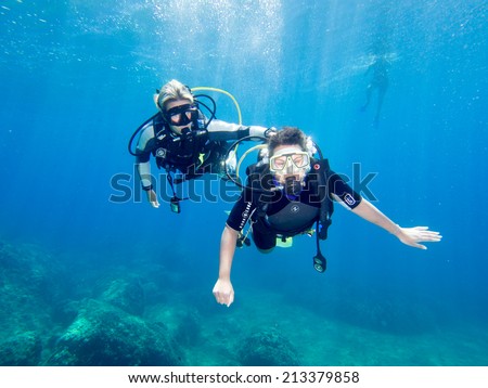LOUTRA,GREECE-AUGUST 24 2014 :Female Scuba Diver taking part in a training dive with her Instructor.More women are taking up diving with dive schools around the world