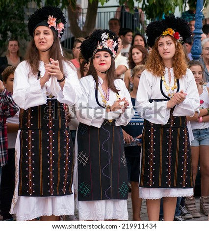 PEFKOHORI , GREECE - SEPTEMBER 19 2014 : Folk Dancers from several countries  taking part in the Annual Folk Dance festival in the village square of Pefkohori ,Greece
