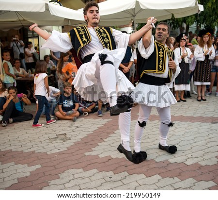 PEFKOHORI , GREECE - SEPTEMBER 19 2014 : Folk Dancers from several countries   dance in the Annual Folk Dance festival in the village square of Pefkohori ,Greece.The Greek dancers perform their dance.