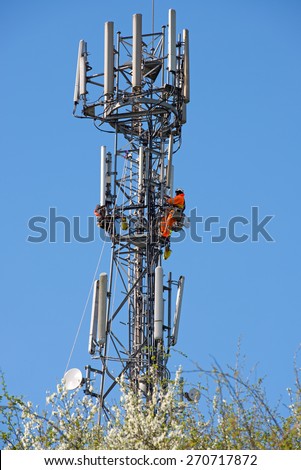 WORCESTER,UK - APRIL 14 2015 : Maintenance workers carry out repairs high up on a communications tower using safety equipment