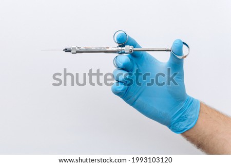 Anesthetist dentist doctor holds in his hand anesthesia syringe prior to dental surgery. Hand in a rubber glove that fits to one side Stock foto © 