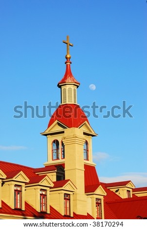 The moon is rising above the roof of the St. Anns academy in downtown victoria, british columbia, canada