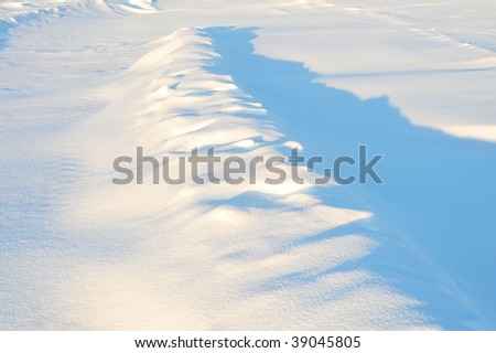 Snow dunes in sunset light in winter field, elk island national park, alberta, canada