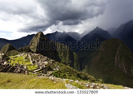 Black rain clouds gather above the ancient lost Inca city Machu Picchu in the Andes mountains in Peru, South America