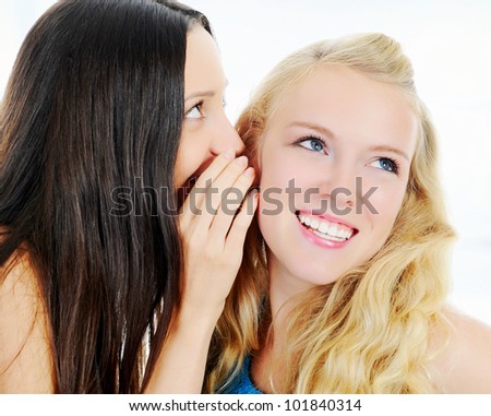 image of a two beautiful women telling secret.