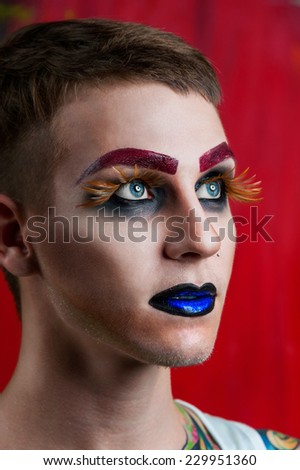 Close-up portrait of the handsome young man fashion model with make-up and big eyelashes
