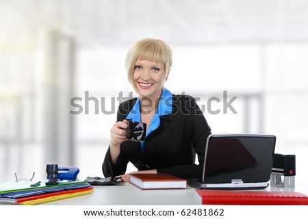 Young woman drinking coffee in the office.