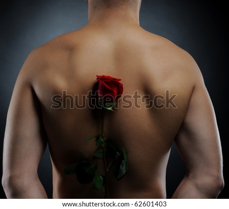 Picture a man  holding a red rose behind his back. Isolated on white background